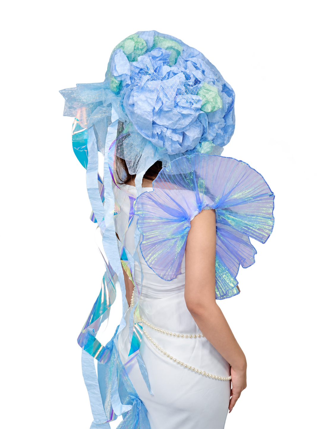 Back view of the completed garment, showing iridescent pleated shoulders and trailing translucent ribbons